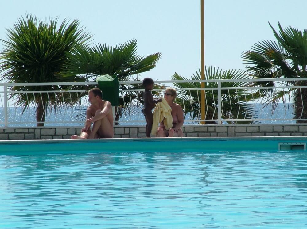 Photo of naturists in an outdoor pool - Nudism helps strengthen friendships